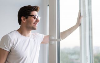 Man opening window in an office