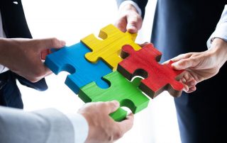 Business people with four jigsaw pieces